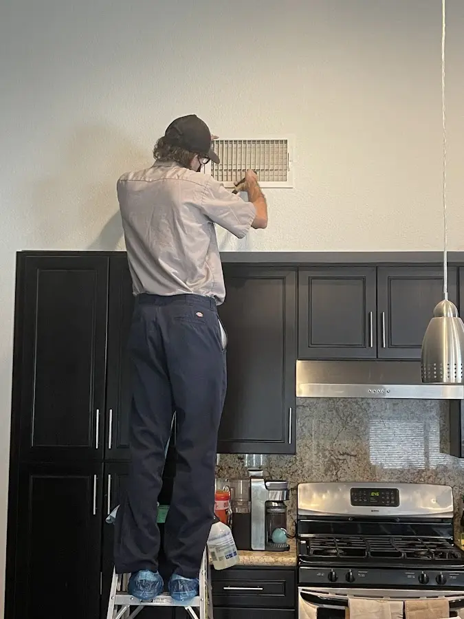 Technician inspecting an air vent during HVAC service in Boiling Springs